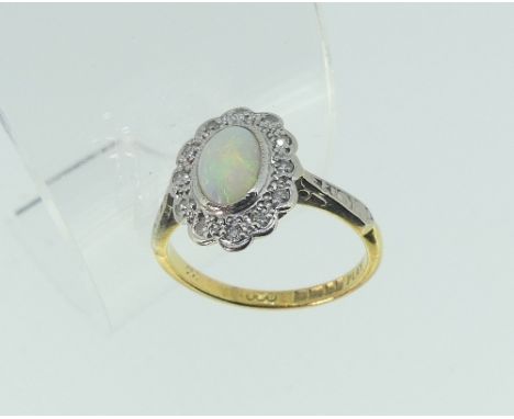 A small oval opal and diamond dress Ring, mounted in platinum and 18ct yellow gold, Size I.