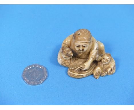 A 19th century Japanese carved ivory Netsuke, depicting a man and boy with a small bird, signed on base, 2in (5cm) wide.   Pr