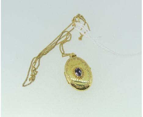 A 9ct yellow gold oval hinged Locket, the front set with a facetted oval amethyst, on a 9ct yellow gold trace chain.