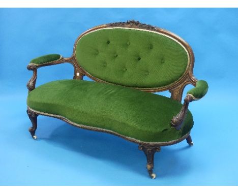 An Edwardian walnut serpentine sofa, with boxwood stringing, carved decoration and green upholstery, 58in (147.25cm) wide.