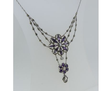 An attractive Necklace, formed of amethyst pastes and marcasite, the centre with an open flowerhead, with a smaller flowerhea