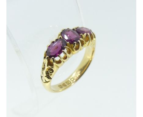 A three stone amethyst Ring, the central oval facetted stone with a similar stone set horizontally on each shoulder, all moun