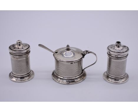 An engine turned silver three piece cruet set, by&nbsp;Sanders &amp; Mackenzie, Birmingham 1932/3. 