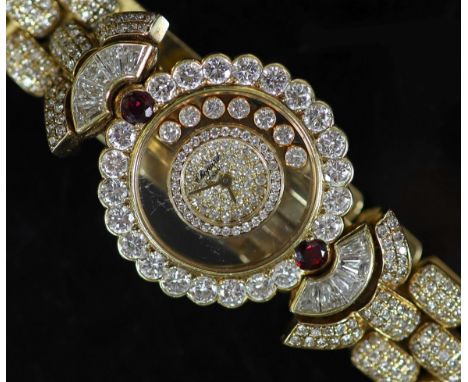 A lady's Chopard 'Happy Diamonds' 18ct gold, ruby and diamond encrusted dress wrist watch,set with trapeze and round cut ston