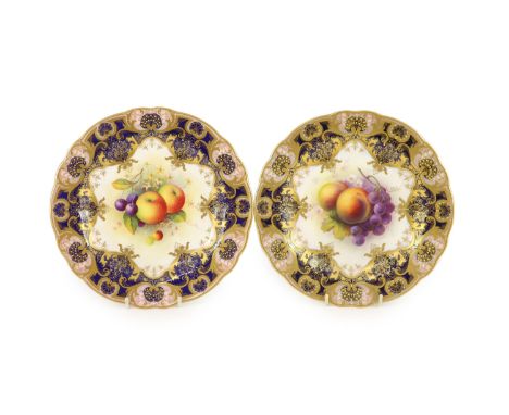 A pair of Royal Worcester fruit painted dessert plates, signed A. Shuck, c.1918 and 1935,each within gilt-decorated cobalt bl