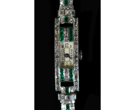 A lady's 1940's/1950's engraved platinum, emerald and diamond set manual wind rectangular cocktail watch, on a 9ct white gold