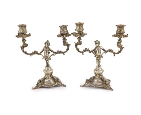 A pair of late Victorian silver two light, two branch candelabra,with figural stems, caryatid terminal arms and floral scroll