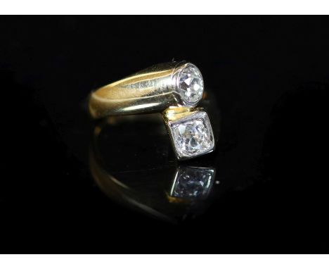 A Continental gold and collet set two stone diamond crossover ring,with a total diamond weight of approximately 0.85ct, size 