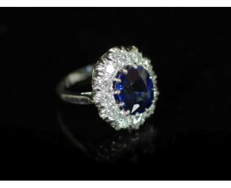 A modern 18ct white gold, sapphire and diamond set oval cluster ring, by Garrard &amp; Co,size I, gross weight 6.3 grams.