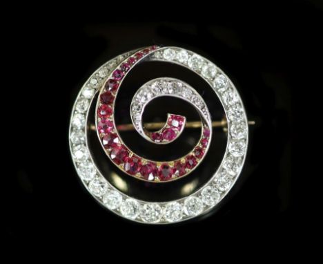 An early 20th century gold and silver, graduated ruby and diamond set open work whorl brooch,27mm, gross weight 9 grams.