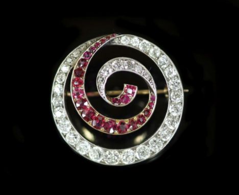 An early 20th century gold and silver, graduated ruby and diamond set open work whorl brooch,27mm, gross weight 9 grams.