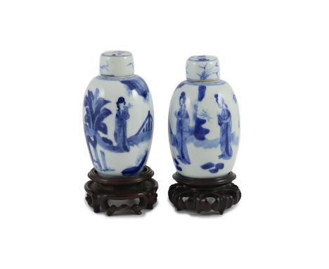 A pair of Chinese blue and white ovoid jars and covers, Kangxi period,each painted with ladies in a garden, the covers with a