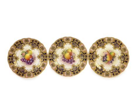 Three Royal Worcester fruit painted dessert plates, signed E. Phillips, c.1918,each within gilt-decorated cobalt blue and pin
