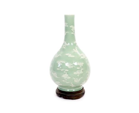 A Chinese celadon-glazed slip-decorated bottle vase, Qianlong seal mark and period (1736-95),decorated in white slip with bat