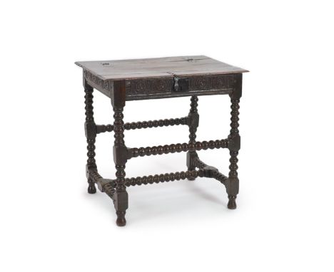 A Charles I joined oak box top tablewith wrought iron hinges and latch, scroll carved frieze and bobbin turned underframe,W 7