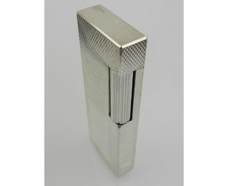 A white metal Dunhill cigarette lighter. 