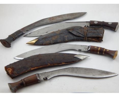 A 20th century Kukri, both handle and scabbard with brass mounts, together with three others 