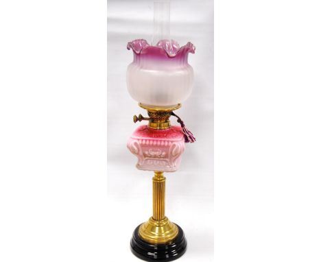 Victorian brass column table oil lamp with cranberry opaline glass reservoir and frosted cranberry glass shade, 68cm high. Co