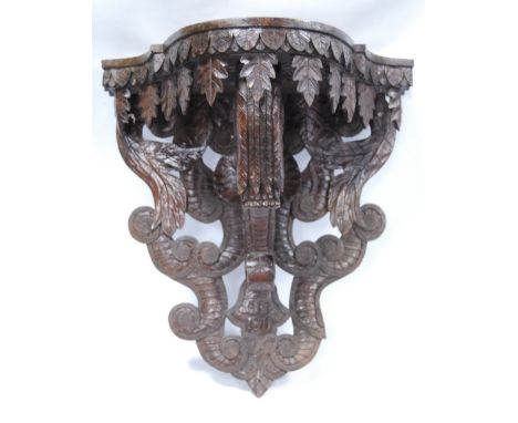 19th century serpentine carved walnut bracket with carved initials, dated 1871, 35cm high.