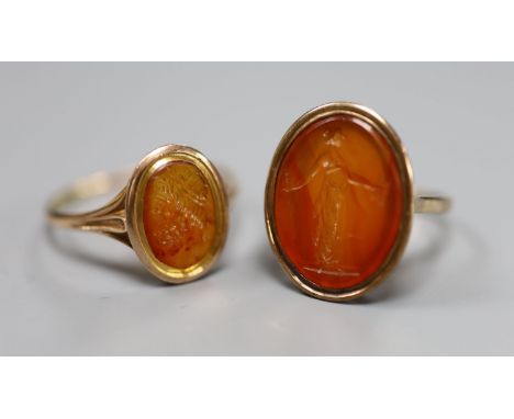 Two 19th century yellow metal and oval carnelian intaglio rings, carved with a bust or figure, one stamped 9ct, sizes U &amp;