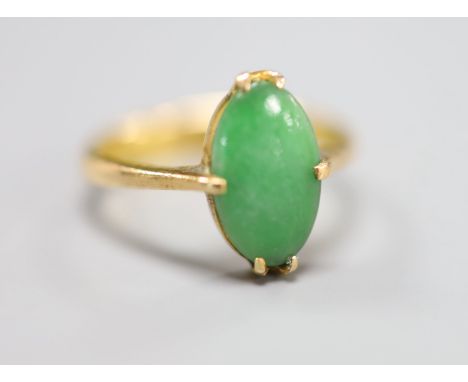 A Chinese yellow metal and oval cabochon jade set ring, size H/I, gross 3 grams.CONDITION: Stone surface very worn.