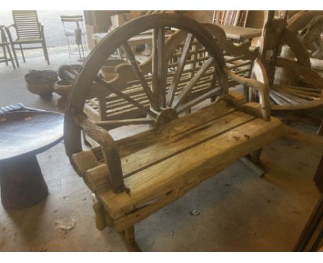 A weathered hardwood cartwheel garden bench, width 140cm depth 70cm height 116cm