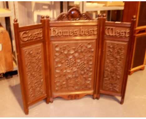 Heavily carved mahogany firescreen with motto East West Homes Best