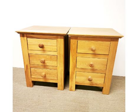 A pair of light oak three drawer bedside tables, 65 x 48.5 x 45cm.
