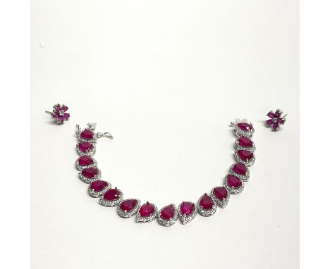 A white metal ruby set bracelet and earrings.