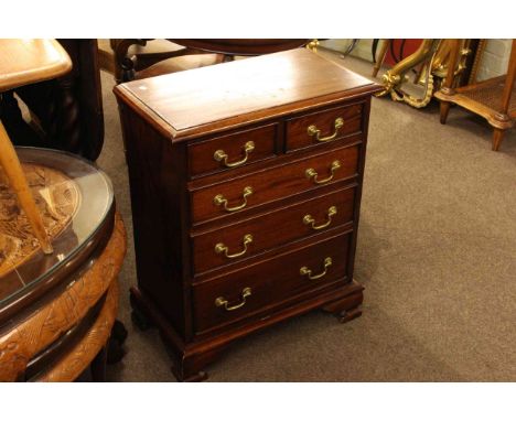 Small mahogany four height chest with brass drop handles on bracket feet