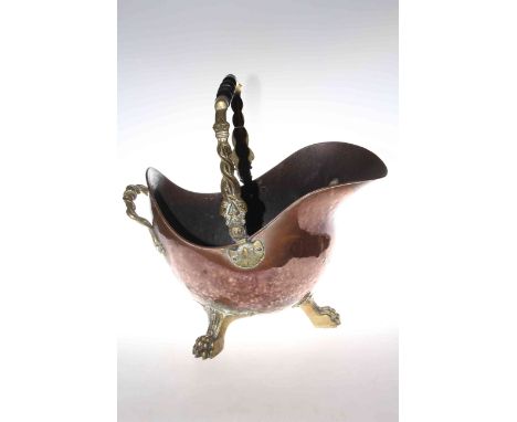 Late 19th Century copper coal helmet raised on three brass paw feet