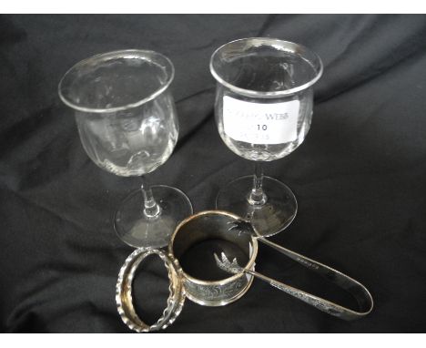 Three etched custard glasses, five other glasses, four hallmarked silver napkin rings, one plated napkin ring and sugar tongs