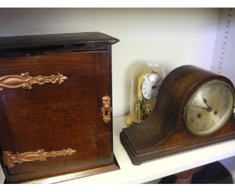 A small oak cabinet, oak cased mantle clock and two other clocks.