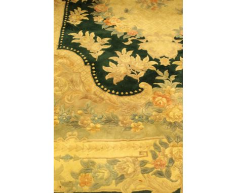 A Chinese superwash rug, the central panel set with floral decorated medallion on a dark green ground, within a stepped dark 