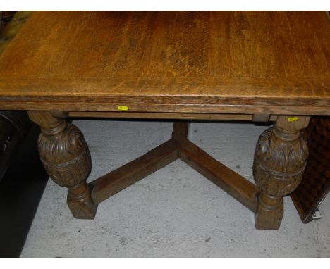 An early to mid 20th Century oak draw-leaf dining table in the Elizabethan Revival taste, on carved and turned cup and cover 