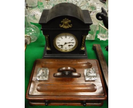 A black slate Victorian mantle clock, the Roman numerals to the enamelled dial, brass Corinthian pilasters and ogee moulded b