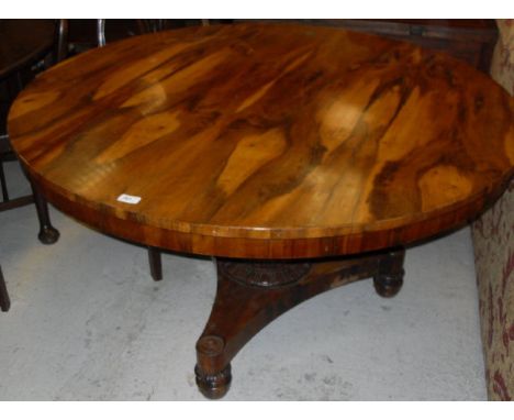 A Victorian rosewood breakfast table, the circular snap top on a turned and carved pedestal to tripod platform base CONDITION