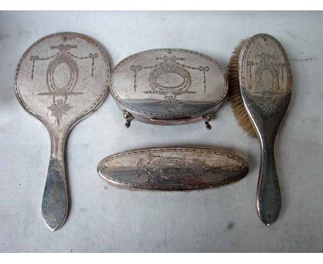 An early 20th century four piece silver Dressing Table Set, comprising two silver back hair brushes, conforming hand mirror a