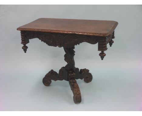 A late Victorian dark oak hall table, rectangular with carved and shaped apron, on tripod base with carved flowers and leaf-s