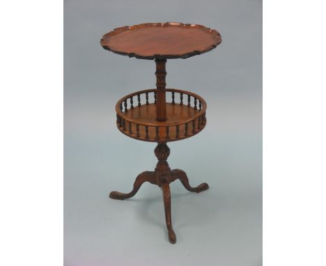 An early 19th century mahogany wine table, circular top with pie-crust border, revolving undertier with spindle gallery, carv