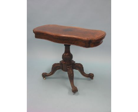 A Victorian burr walnut card table, serpentine-shape with revolving top, on carved, bulbous stem and four outswept feet with 