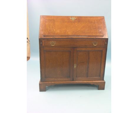 A Georgian oak bureau, 18th century, first-half, fall-front enclosing stepped interior with well, pair of panelled cupboard d