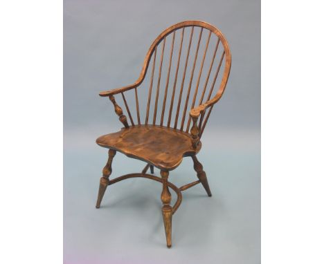 An American-style beech stick-back elbow chair, with shaped seat, turned underframe with crinoline stretcher