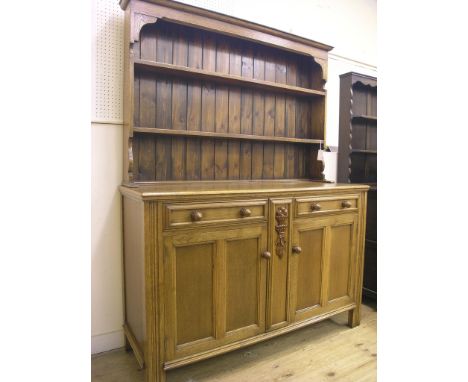 A medium oak dresser, twin-shelf plate rack above panelled cupboard base with two drawers, 4ft. 6in.