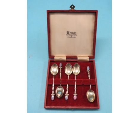 A part set of five silver and black opal coffee spoons, scroll stems each with oval black opal surmount, in fitted case 