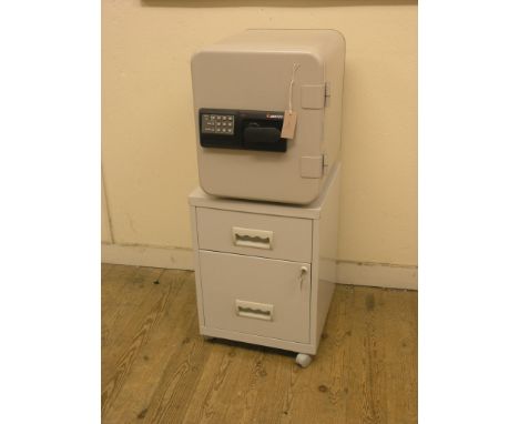A Sentry domestic safe, combination lock with code 42141, with owner's manual, on modern grey metal filing drawer unit