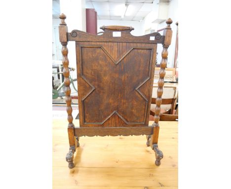 An early 20th Century Jacobean Revival carved oak fire screen 