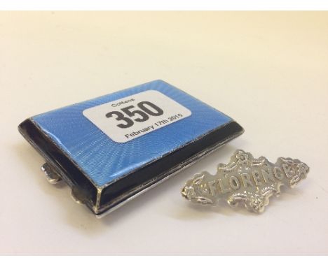 A silver and enamel matchbook case together with a silver name brooch 'Florence'.