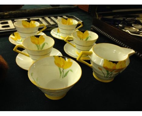 The residue of a Paragon Art Deco bone china coffee service, decorated with yellow crocus flowers comprising four cups and sa