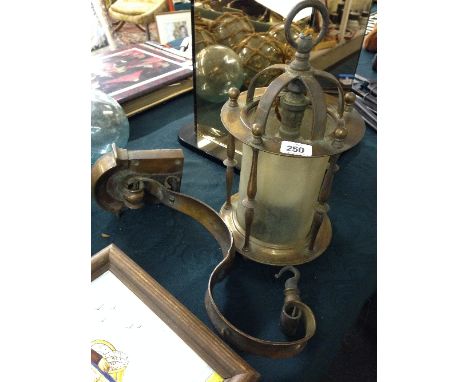 An Art Nouveau copper hanging lantern with glass liner and scrolling wall bracket (fitted for electric).